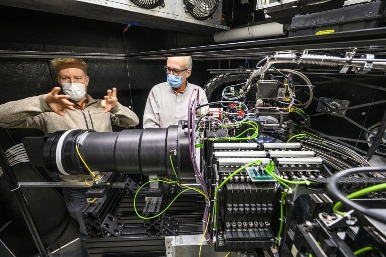 Instrument engineer Mike Smith, left, and senior scientist Jeff Percival describe the functions of the spectrograph they designed, built and programmed. PHOTO BY: JEFF MILLER