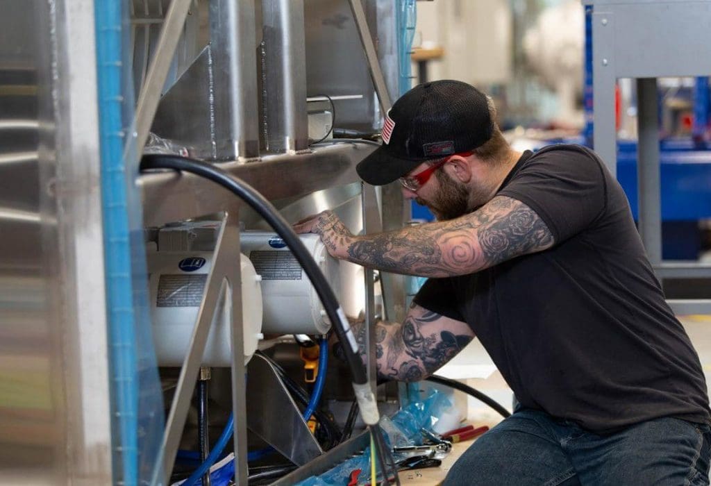 Adam Rolling, SHINE Technologies staff member, operates machinery inside the company's Fitchburg-based manufacturing facility. COUTRESTY OF SHINE TECHNOLOGIES