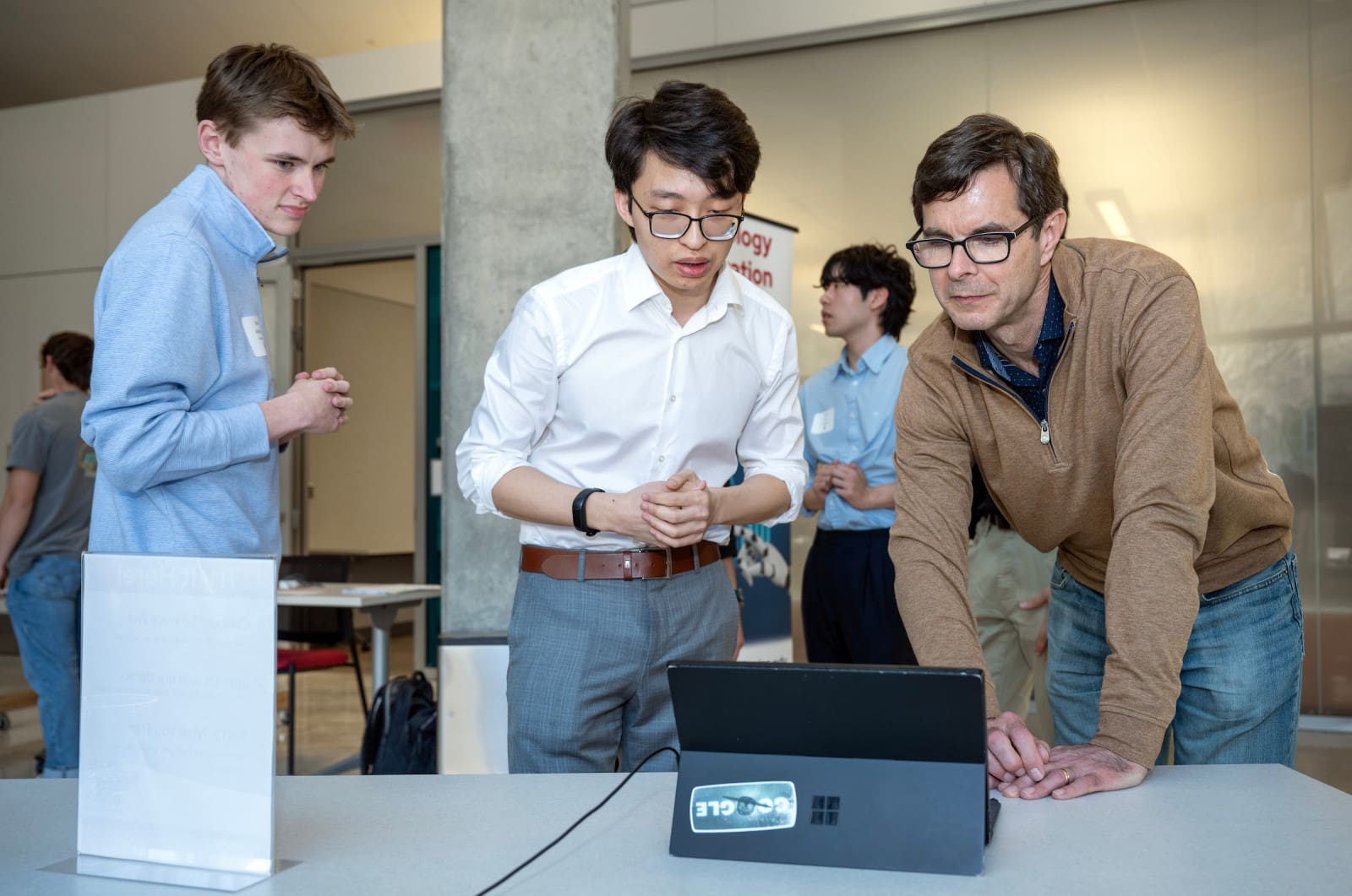 Crystal Farms CFO Rick Hausman (right) looks over the Retail Promotions Strategies team concept as he talks with Albert Wu (center) and Isaac Anderson (left) during the Spring Technology Exploration Lab Showcase on Thursday, April 24, 2025, at the Wisconsin Institute of Discovery. Photo: Paul L. Newby II, UW–Madison Wisconsin School of Business